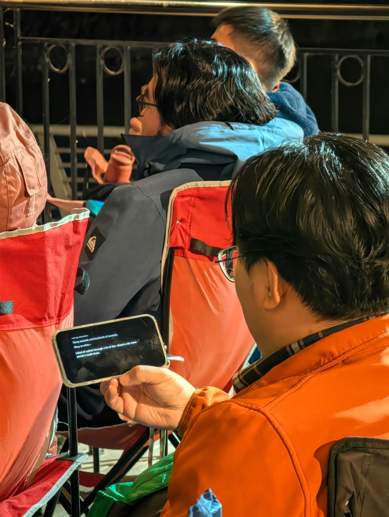 An audience member follows live captions on a smartphone during the event